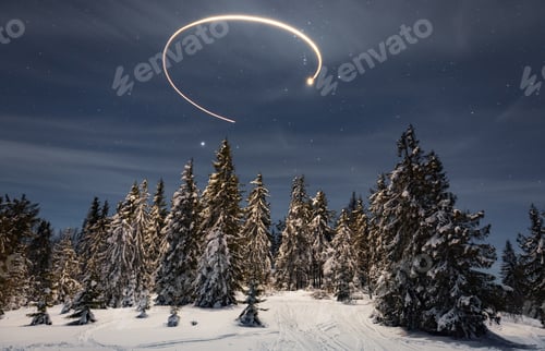 Preview: New Year's trail from a star in the night sky as a background for snow-covered trees in a