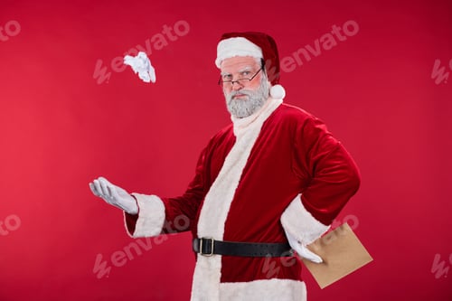 Preview: Throwing Paper Ball in Santa Clause Costume Against Red Wall