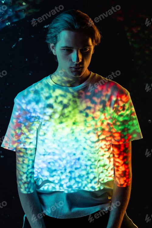 Preview: Man looking on colorful spots on T-shirt