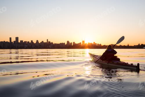 Preview: Adventurous girl on a sea kayak is kayaking during a vibrant sunny sunrise