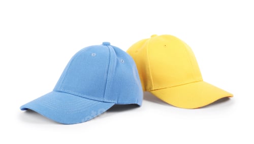 Preview: Blue and yellow baseball caps isolated on white. Mockup for design