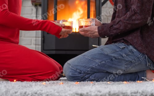 Preview: Man and woman in love date at home are sitting near the fireplace stove