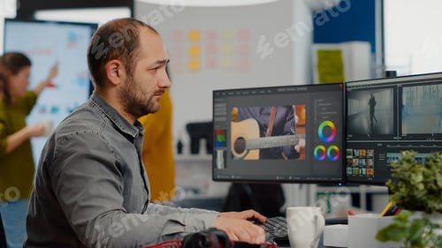 Preview: Videographer looking at camera smiling working in creative startup workplace