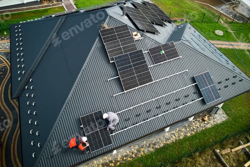Preview: Men workers installing solar panels on roof of house.