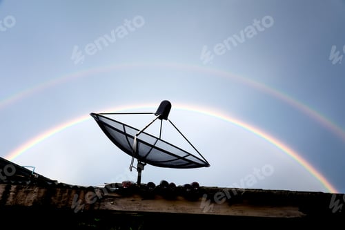 Preview: satellite dish on the roof against rainbow sky