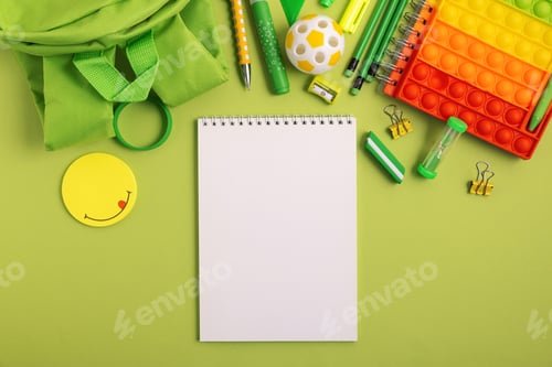 Preview: Mockup from notebook with school stationery supplies on green background. Top view. Copy space