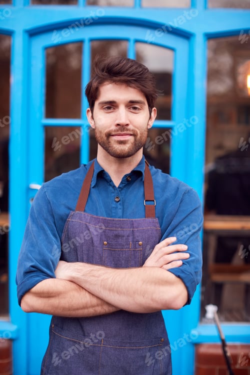 Preview: Portrait Of Male Small Business Owner Wearing Apron Standing Outside Shop On Local High Street