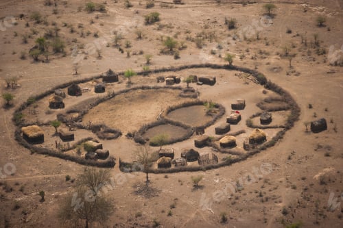 Preview: An aerial view of a small village settlement, with buildings and animal enclosures,