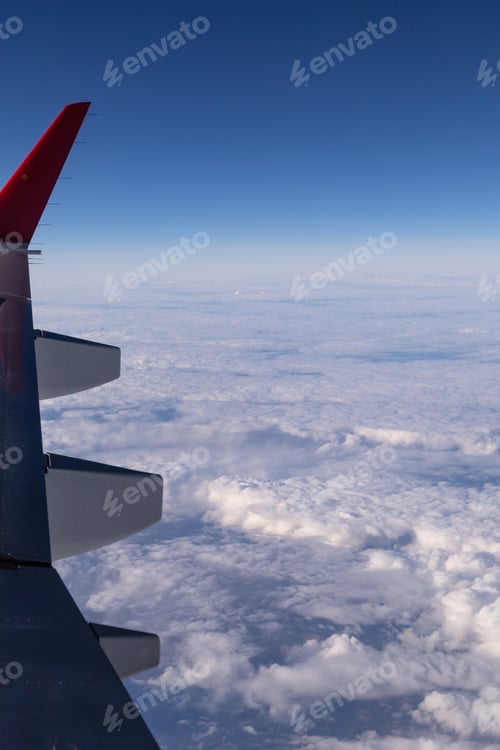 Preview: the wing of a flying aircraft against the background of clouds