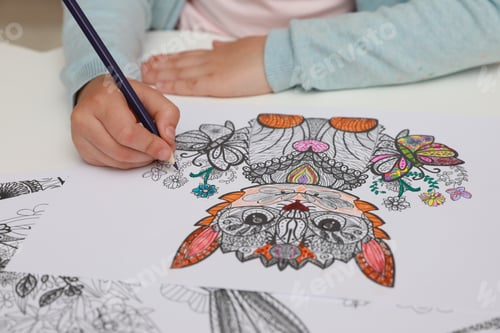 Preview: Little girl coloring antistress page at table, closeup