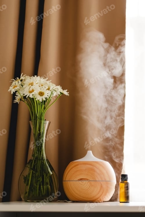 Preview: Aromatherapy concept. Aroma oil diffuser on the table against the window.