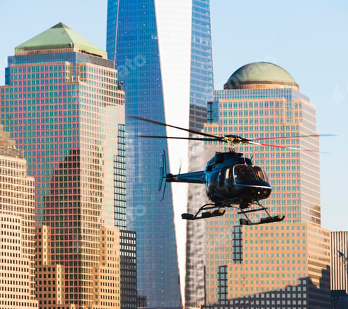 Preview: Helicopter flying near skyscrapers at dusk.