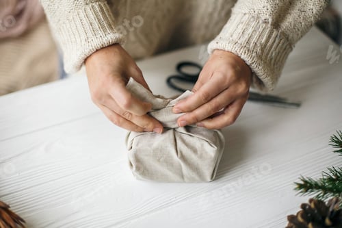 Preview: Woman in cozy sweater preparing plastic free christmas present,