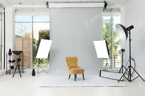 Preview: Interior of modern photo studio with armchair and professional equipment