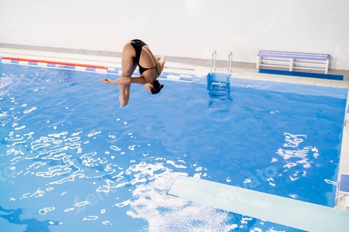 Preview: a girl doing extreme tricks jumping into water, spring-board diving championships