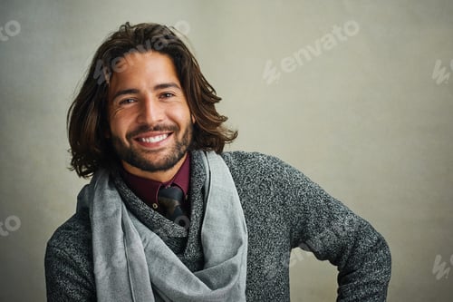 Preview: Portrait of a stylishly dressed man posing against a gray background in the studio