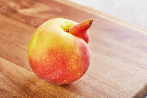 Preview: ugly fruit or vegetable. Heavily ugly peach mutant on a wooden background.