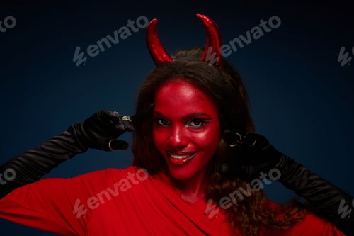 Preview: A stunning woman in a vibrant Halloween costume poses with confidence against a dark background