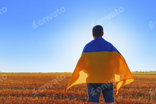 Preview: Man with a flag of Ukraine standing in field