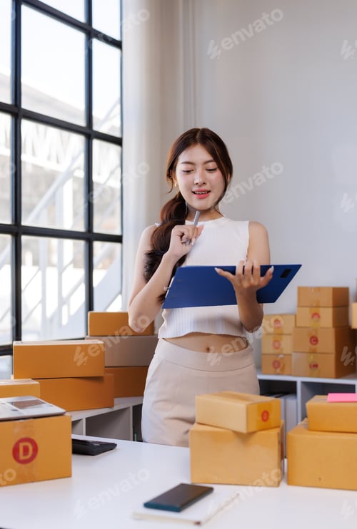 Preview: Young woman managing online store checking shipping orders