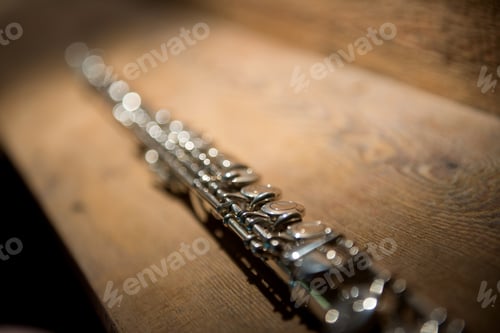 Preview: Music instrument silver flute on a wooden background,beautiful light