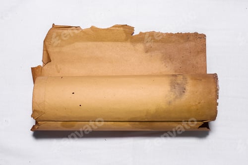 Preview: A rolled-up piece of parchment or paper that is torn and stained, appears aged and worn