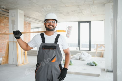 Preview: An Indian apartment repair worker paints a white wall with a roller
