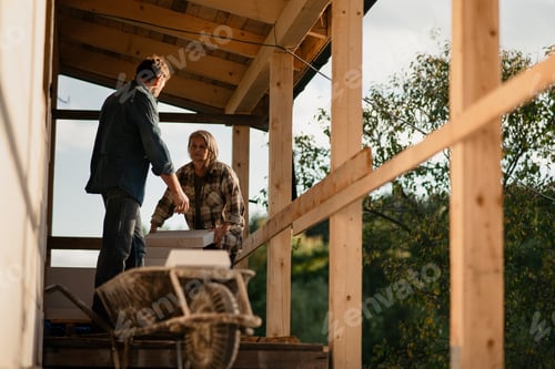 Preview: Mature couple working together on construction site of their new house.