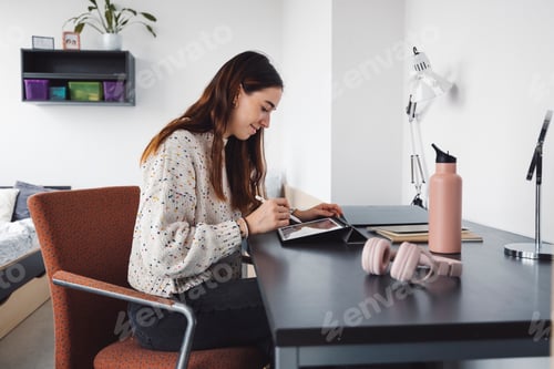 Preview: Young caucasian woman studiying art, doing homework in her dorm room