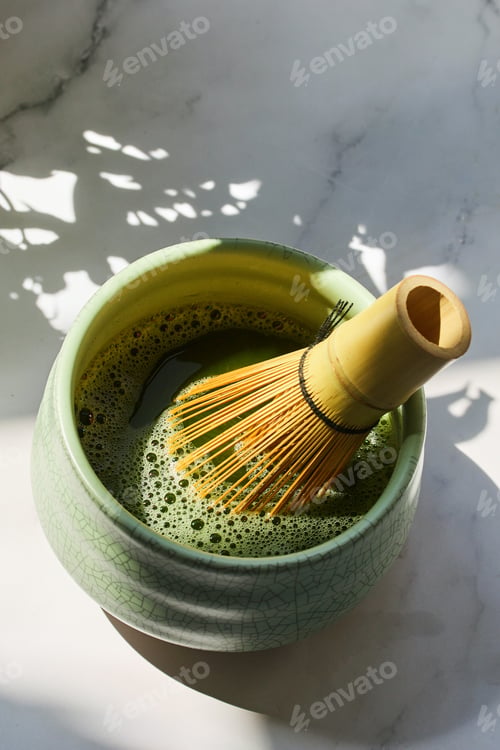 Preview: Matcha Preparation. A bamboo whisk in a bowl of frothy matcha,