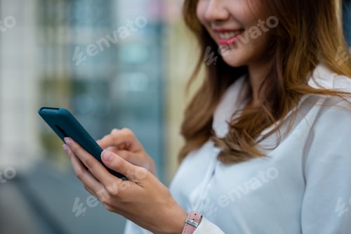Preview: A woman in a white shirt using her smartphone for business
