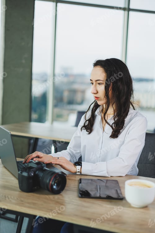 Preview: Young female photographer working on a tablet, retouching photos on a portable tablet
