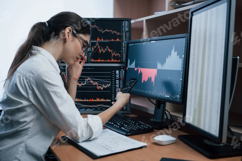 Preview: Woman working online in the office with multiple computer screens in index charts