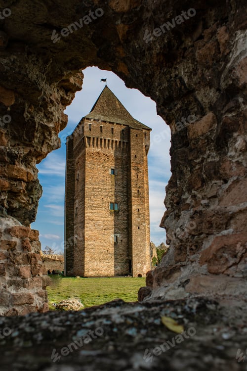 Preview: Vertical shot of the hole of the stone with the background of a medieval Bac fortress in Bac, Serbia