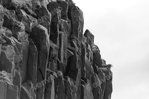 Preview: Black and white closeup shot of the big rock formations on the beach