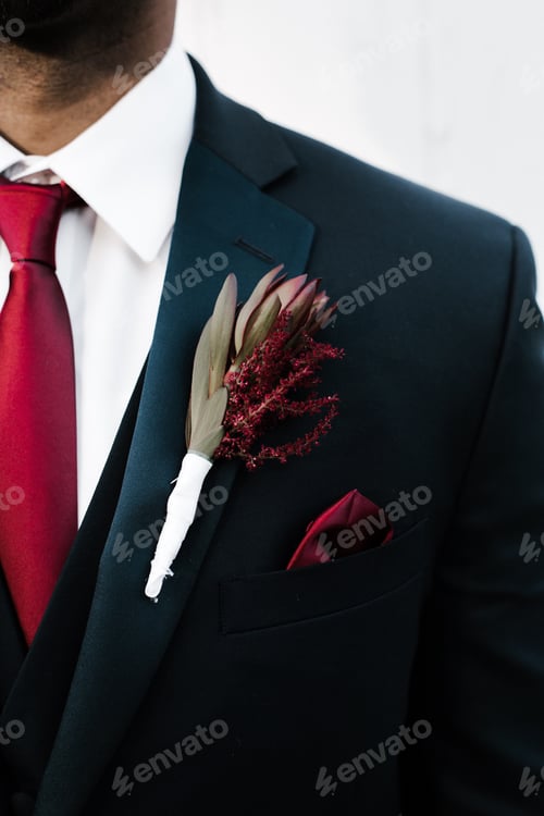 Preview: Man dressed in formal attire in navy suit with a red tie