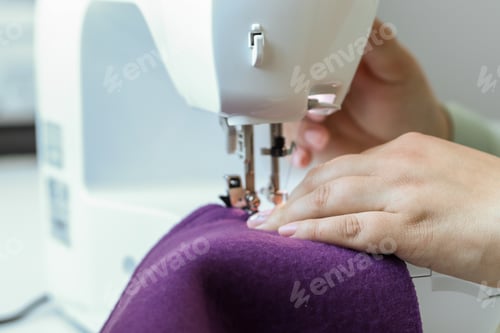 Preview: A woman sews children's clothes on a sewing machine. Hands of a seamstress. seamstress profession