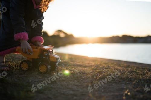 Preview: Child Playing with a Toy Dump Truck Outside