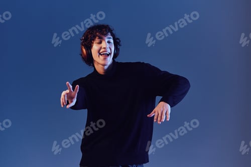 Preview: Man wearing headphones listening to music and dancing, DJ happiness and smile, hipster shows sign