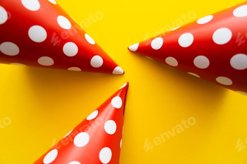 Preview: Top view of dotted party caps on yellow background