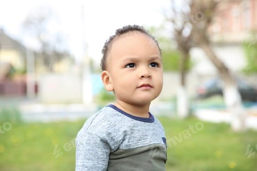 Preview: Cute African-American baby in stylish clothes posing outdoors