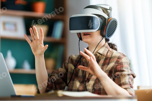 Preview: Woman Experiencing Virtual Reality at Home Office with VR Headset and Headphones