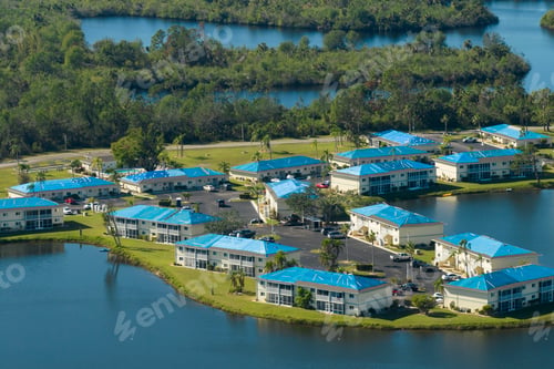 Preview: Apartment building roofs covered with blue protective tarp against rain water leaking
