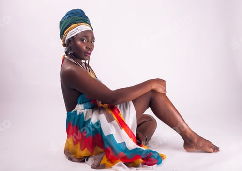 Preview: Studio fashion portrait of young African woman in summer dress and ethnic head wrap