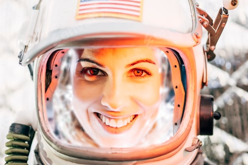 Preview: Beautiful woman poses looking at camera dressed as an astronaut.