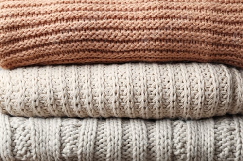 Preview: Stack of knitted sweaters close up view