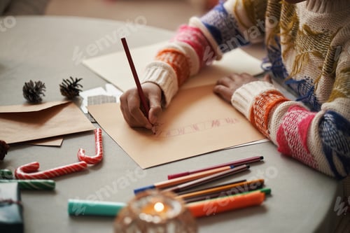Preview: Caucasian Child Drawing Christmas Card While Sitting at Table Indoors