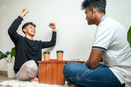 Preview: Young Man Winning The Dominoes Game Against His Friend