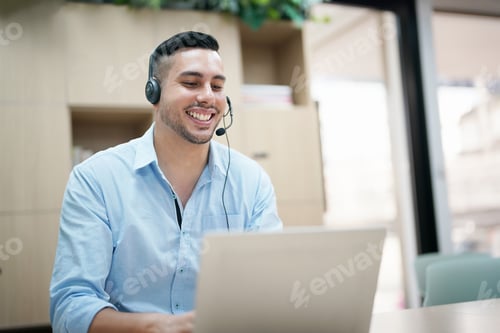 Preview: Young man sitting in office and working on desktop pc. Businessman looking at computer monitor while