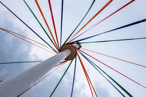 Preview: Low angle shot of a classic English Maypole during a dancing festival under a cloudy sky